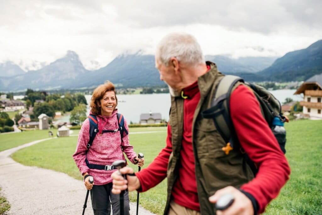 senior couple who is aging gracefully hiking on a trail in the mountains