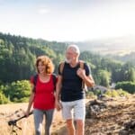 senior couple on a hike together to reduce their risks of high cholesterol by exercising