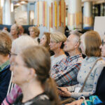 people sitting in chairs at an event
