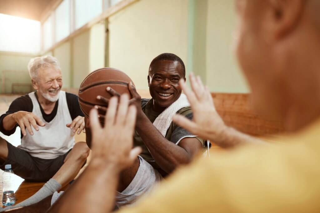 man who has chosen to live in an independent senior living and retirement community playing basketball with his friends