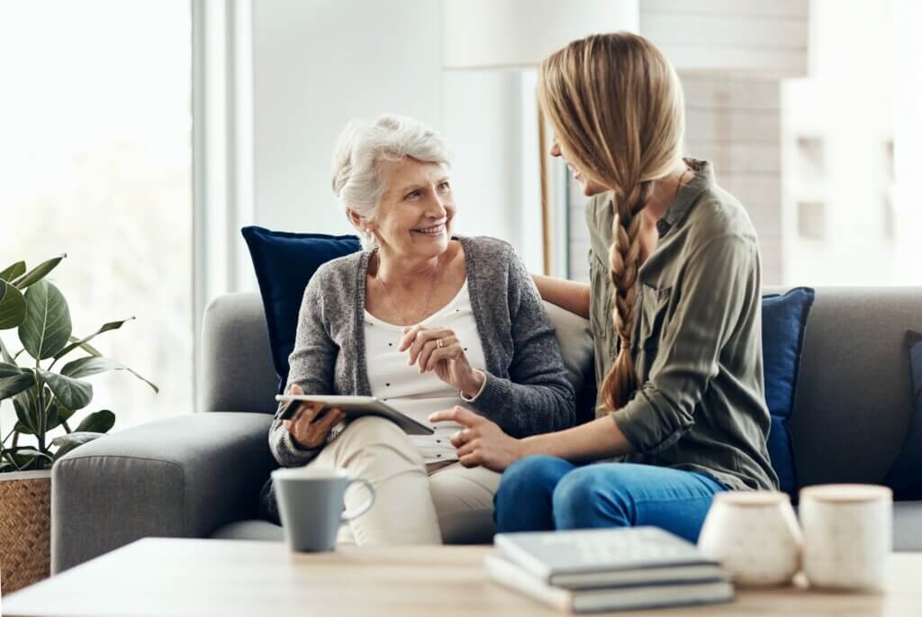 caregiver sitting on the couch at home with a loved one who has dementia
