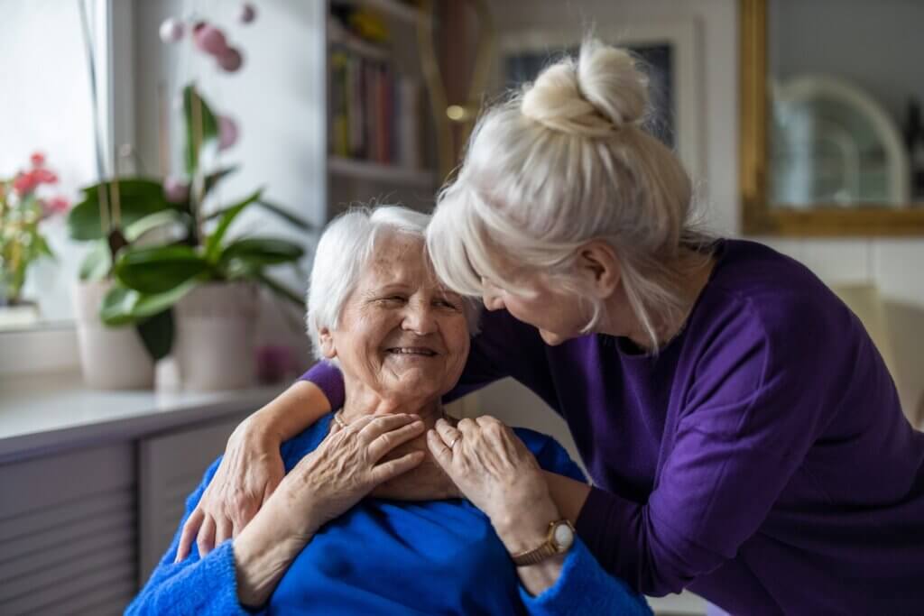 woman embracing and providing comfort to someone with dementia who is receiving care in her home