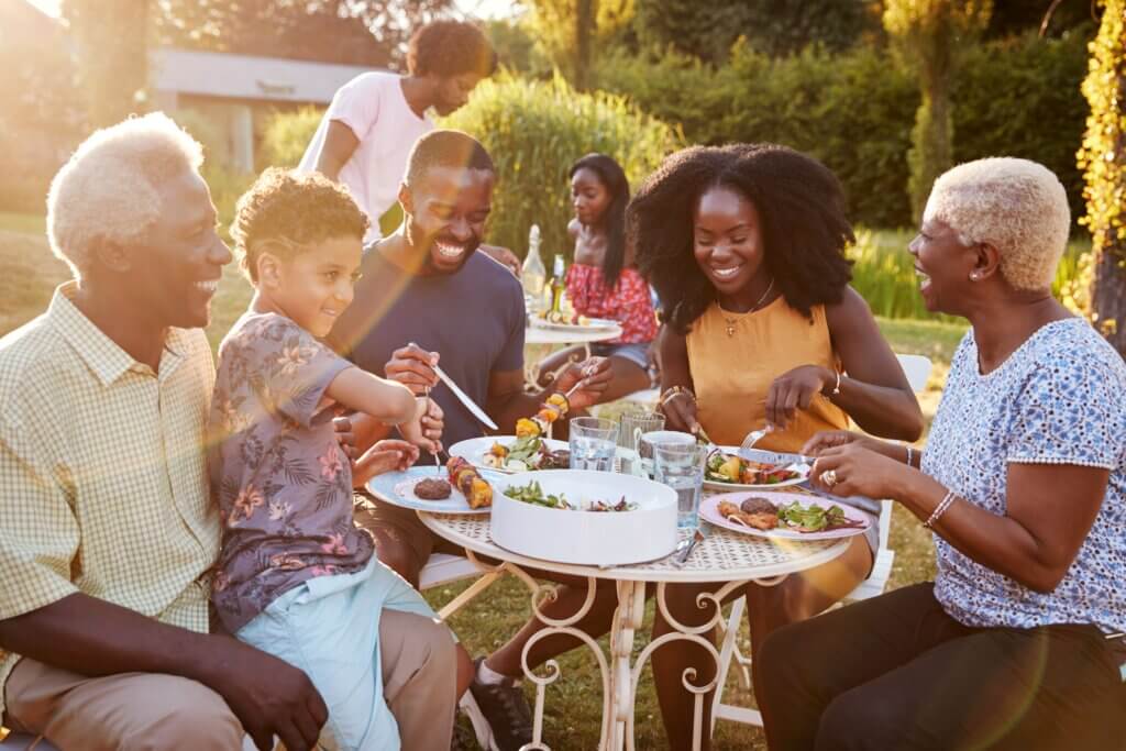 group of people gathering together at a table while enjoying a glucose friendly meal outside