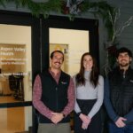 three people standing outside the front doors of the Aspen Valley Health rehabilitation and sports medicine location in downtown