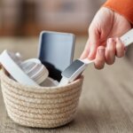 hand placing technology and devices into a basket for a digital detox retreat