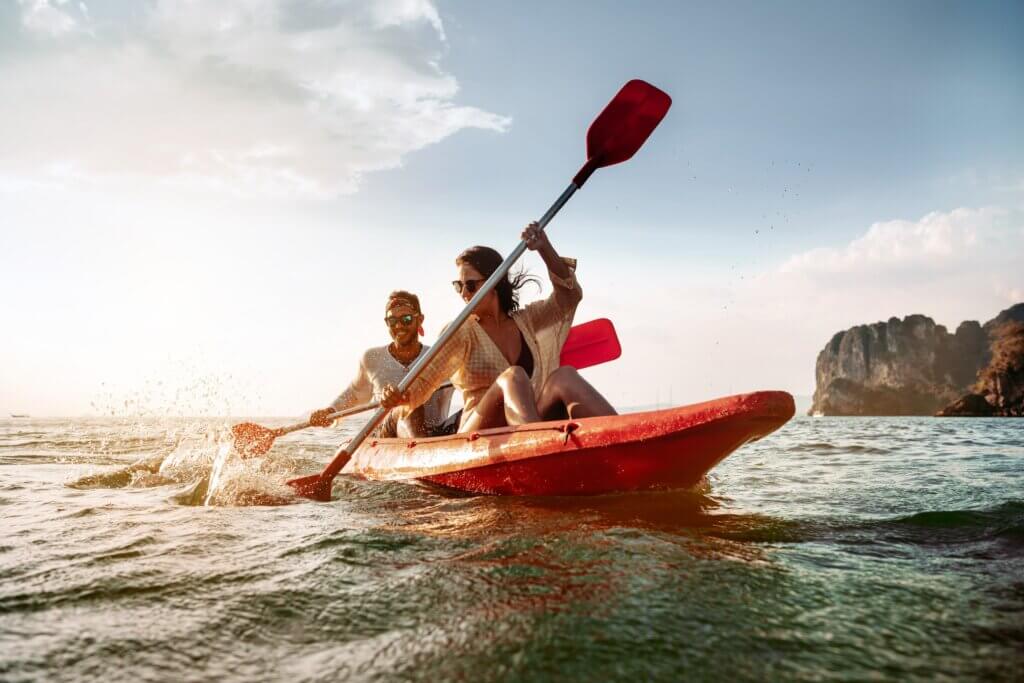 couple on a digital detox retreat canoeing in the ocean