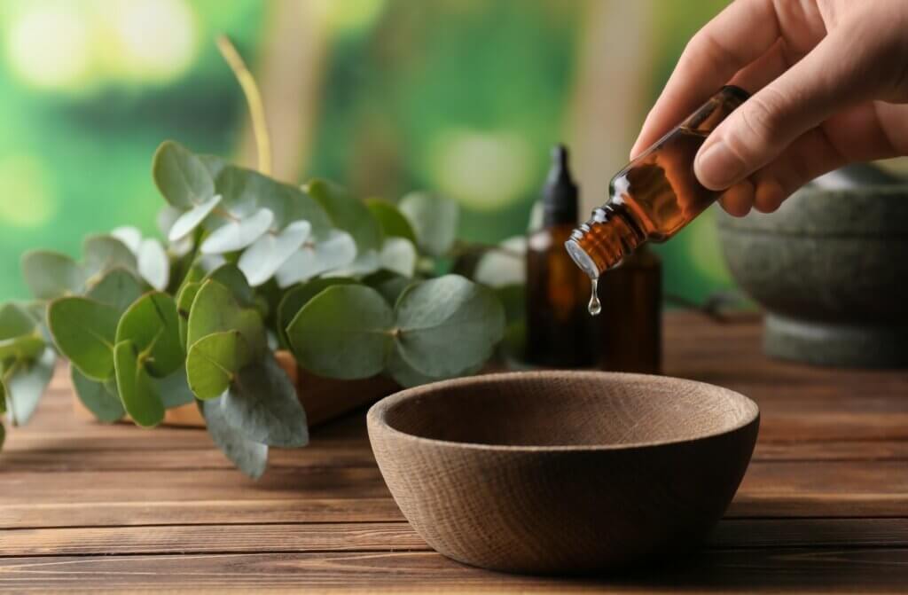 hand dropping drops of eucalyptus essential oils into a bowl to help with congestion
