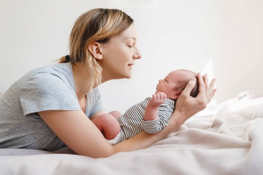 mom with postpartum brain fog holding her baby in her arms and looking at him