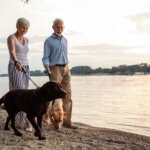 man and woman walking their two dogs outside showing the importance of getting outside when you have amnesia vs dementia