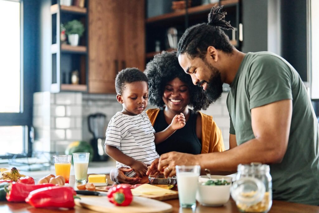 family with a toddler sitting in a kitchen and cooking a meal together to support and promote the health of their gut