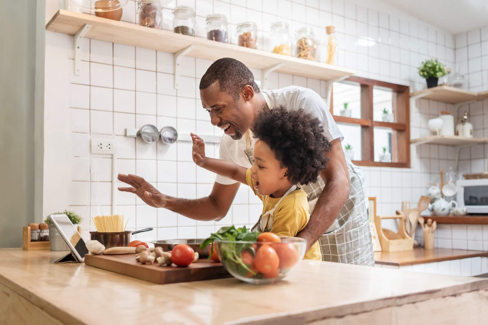 man showing his child how to cook with the best foods for colon health