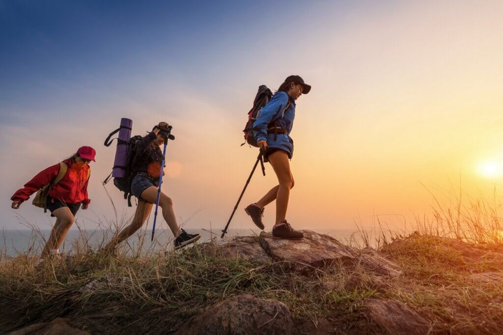 three women preventing blisters on their long hike in the mountains by wearing acrylic socks with well-fitted hiking boots