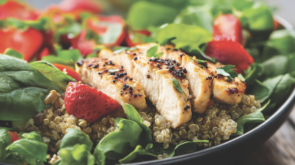 grilled chicken on a bed of spinach and quinoa and strawberries