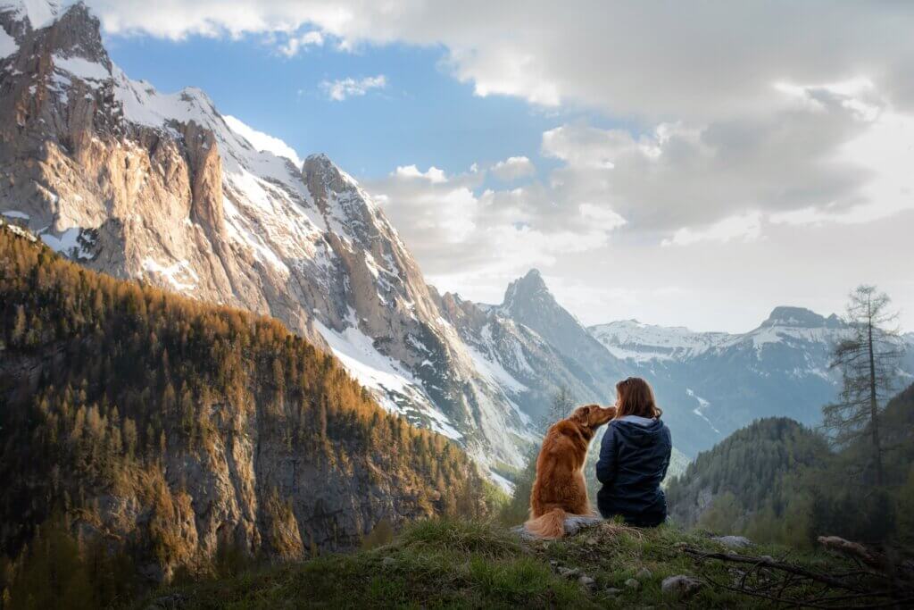 woman hiking her with her dog in the mountains to reduce her silent acid reflux symptoms